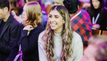A photograph of an attendee in the audience at DO Conference