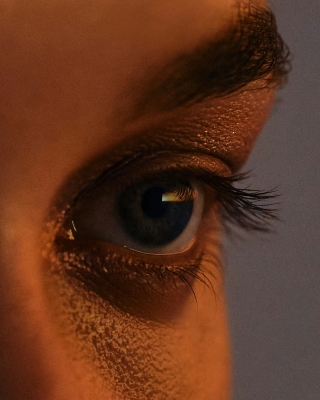 An extreme close-up of a person’s eye, showing fine details of the eyelashes and reflections in the pupil.