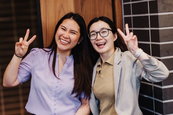 Two smiling attendees flash peace signs at Design Leadership 2025, capturing a joyful moment of connection during the event.