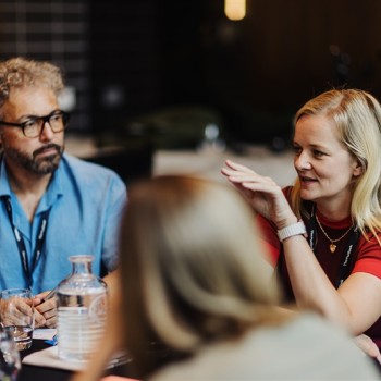 Attendees at table 11 engage in a focused conversation during a breakout session at Design Leadership 2025, exchanging insights and ideas.