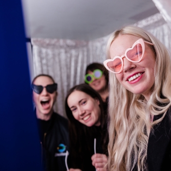 Attendees posing with playful sunglasses in the Torii photobooth at The Outlook 2025, smiling in front of a backgdrop.