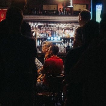 View of man sitting at a bar table in dim light